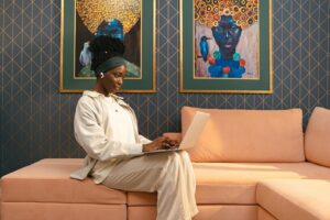 Woman Sitting on Sofa Working on Laptop